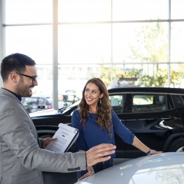 toco extended car warranty service happy woman and man in front of car signing car warranty